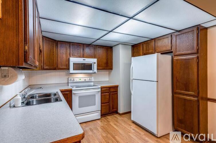 A kitchen with wooden cabinets and white appliances.