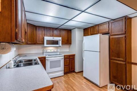 A kitchen with wooden cabinets and white appliances.