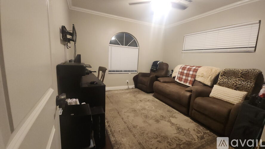 A living room with a brown couch and a black entertainment center.