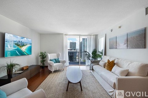 A living room with a large painting on the wall and a view of a city skyline.