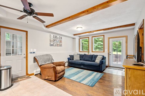 A living room with a blue couch and a brown chair.