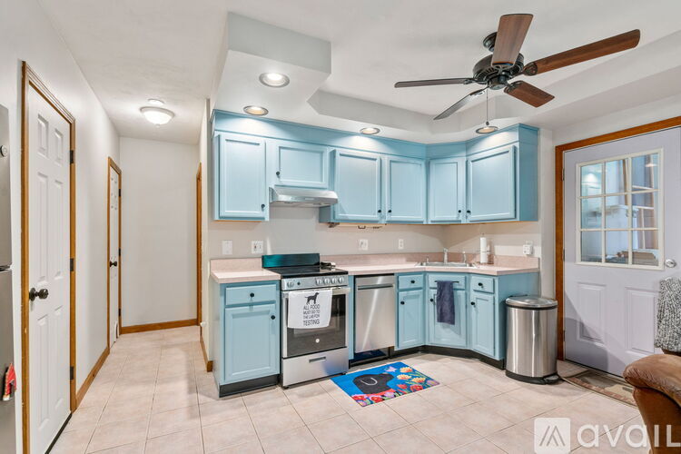 A kitchen with blue cabinets and a fan.