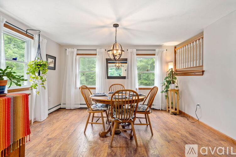 A dining room with a wooden table and chairs.