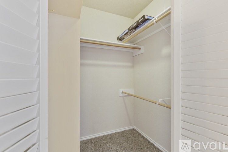 A small, white closet with a shelf and a hanging rod.
