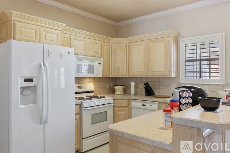 A kitchen with wooden cabinets and a white refrigerator.