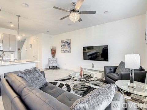 A modern living room with a grey sofa and a glass coffee table.