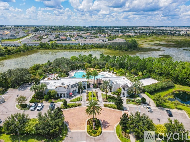 A bird's eye view of a resort with a swimming pool and palm trees.