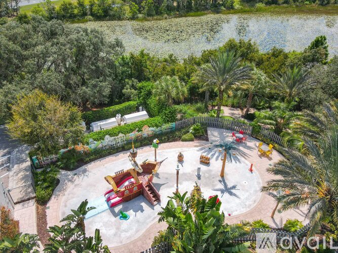 An aerial view of a water park with a large water slide and palm trees.