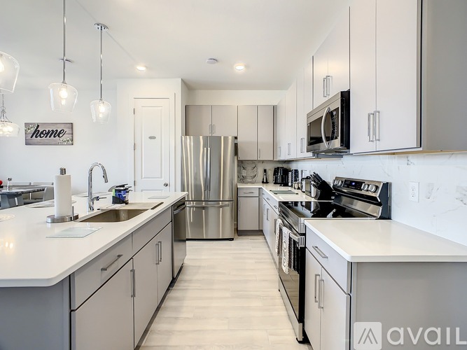 A modern kitchen with stainless steel appliances and white cabinetry.