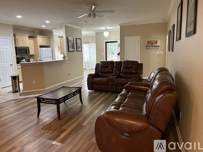 A living room with brown leather couches and a wooden coffee table.