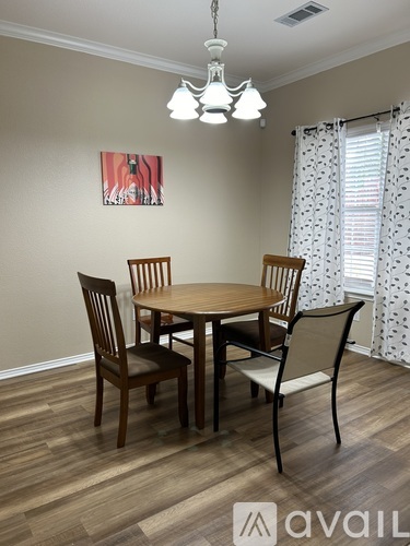 A dining room with a wooden table and chairs.