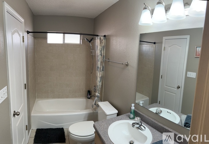 A bathroom with a white toilet, sink, and bathtub.