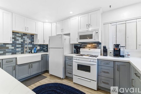 A kitchen with white appliances and a white counter top.