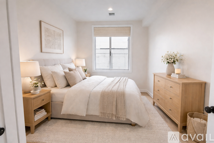 A bedroom with a bed, nightstand, and window.