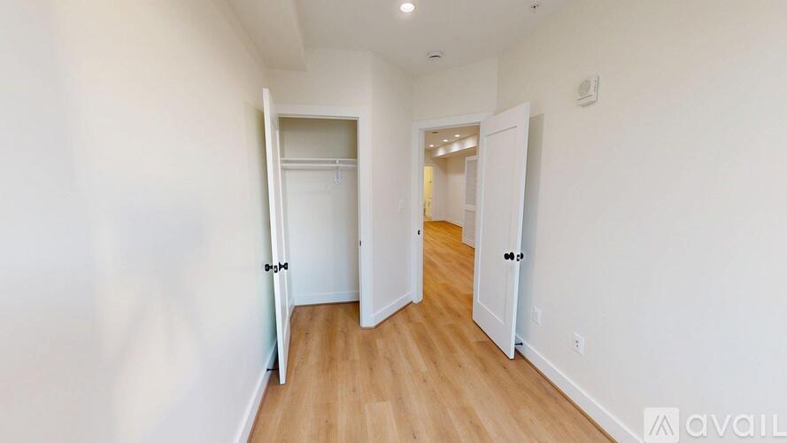 A hallway with two doors on either side and a wooden floor.