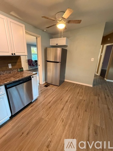 A kitchen with a refrigerator and a fan.