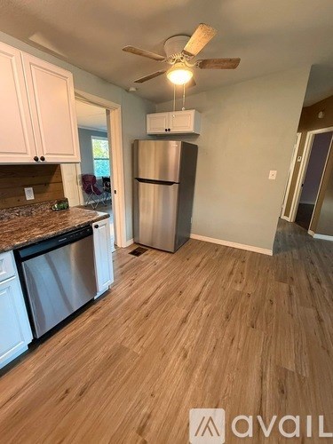 A kitchen with a refrigerator and a fan.