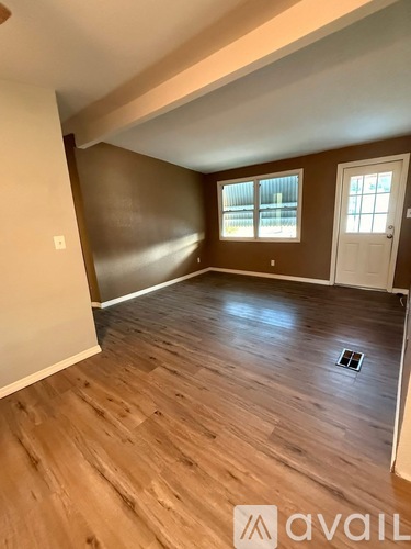 A room with wooden flooring and a window.