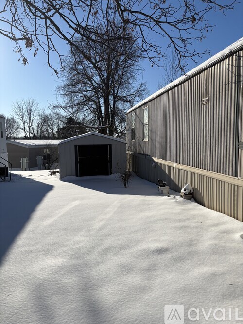 A snow-covered yard with a house and a garage.