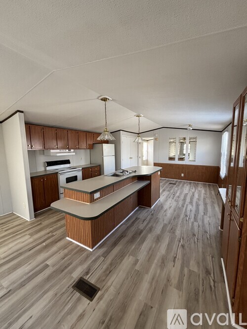 A kitchen with wooden floors and a central island.