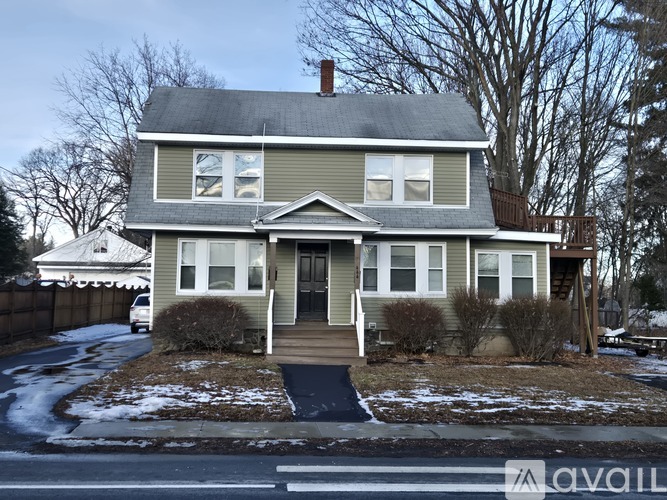 A two-story house with a grey roof and white trim.