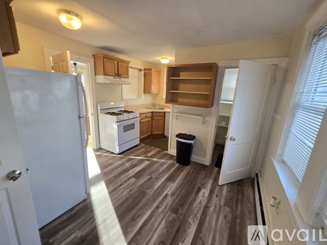 A kitchen with a white refrigerator and wooden floors.