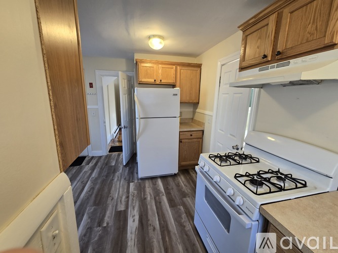 A kitchen with a white stove and a white refrigerator.