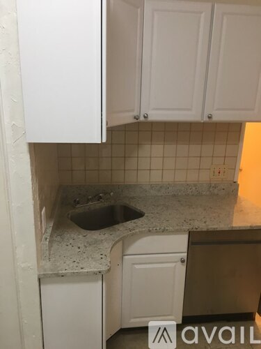 A kitchen with white cabinets and a granite countertop.