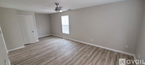 A room with wooden flooring and a ceiling fan.