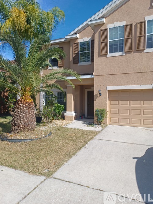 A house with a palm tree in front.