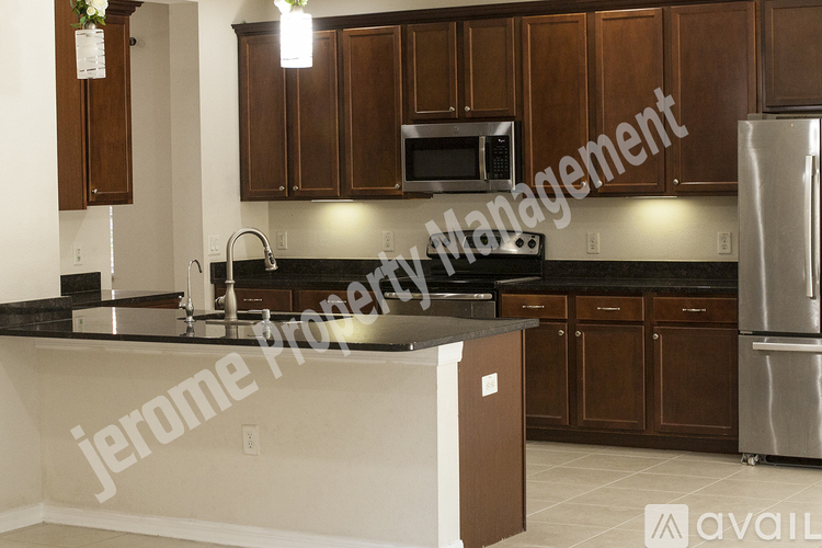 A kitchen with brown cabinets and a black countertop.