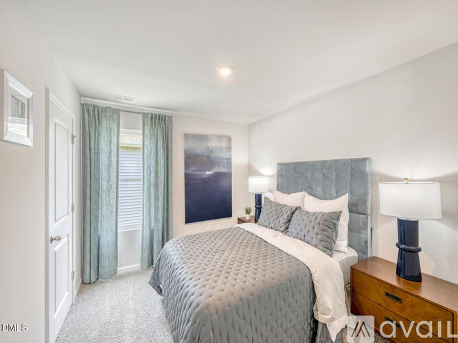 A well-lit bedroom with a large bed and a window with curtains.