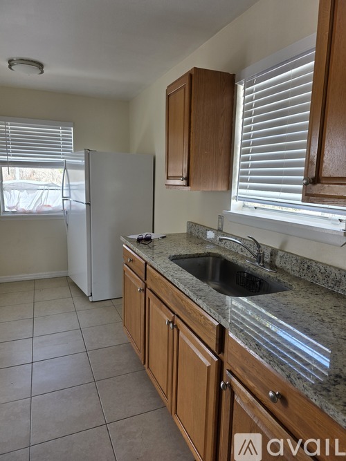 A kitchen with a white refrigerator and wooden cabinets.