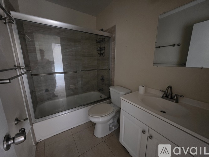 A spacious room with tiled flooring and white walls.
