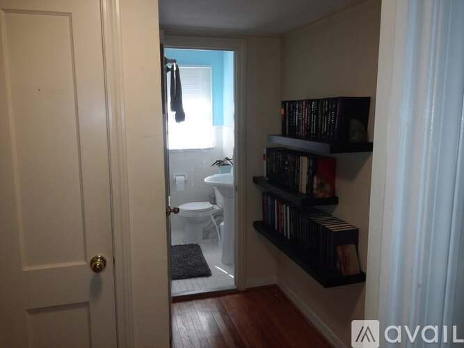 A bathroom with a toilet and sink is visible through an open door.