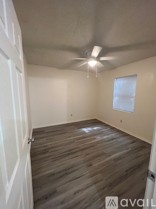 A room with wooden flooring and a ceiling fan.