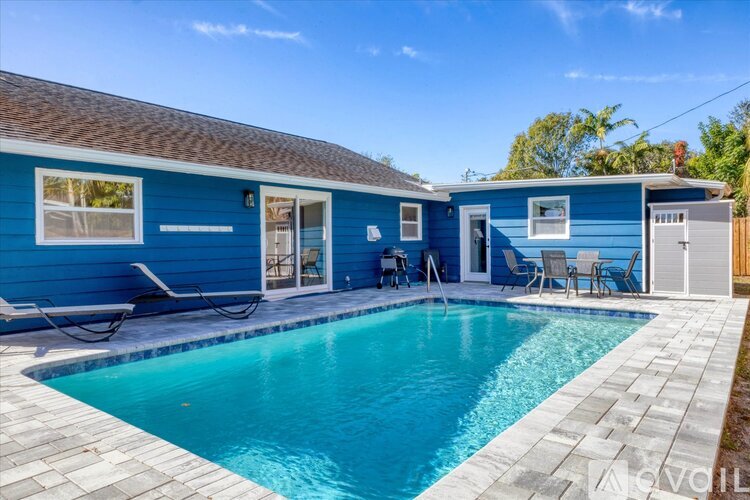 A blue house with a pool in front.