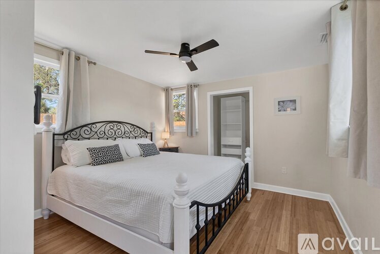 A bedroom with a large bed and a ceiling fan.