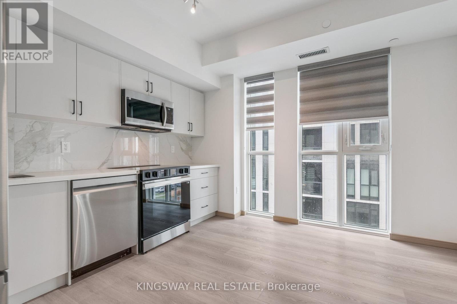 A kitchen with a stainless steel oven and microwave.