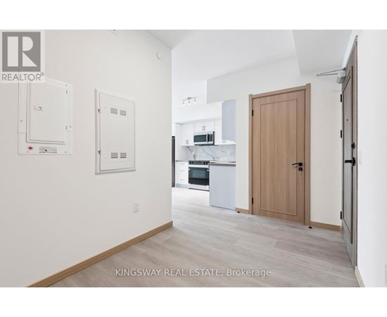 A kitchen area with a refrigerator, oven, and sink.