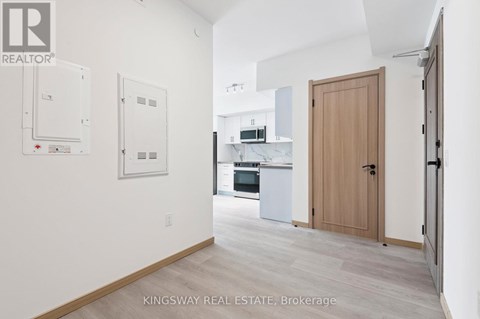 A kitchen area with a refrigerator, oven, and sink.
