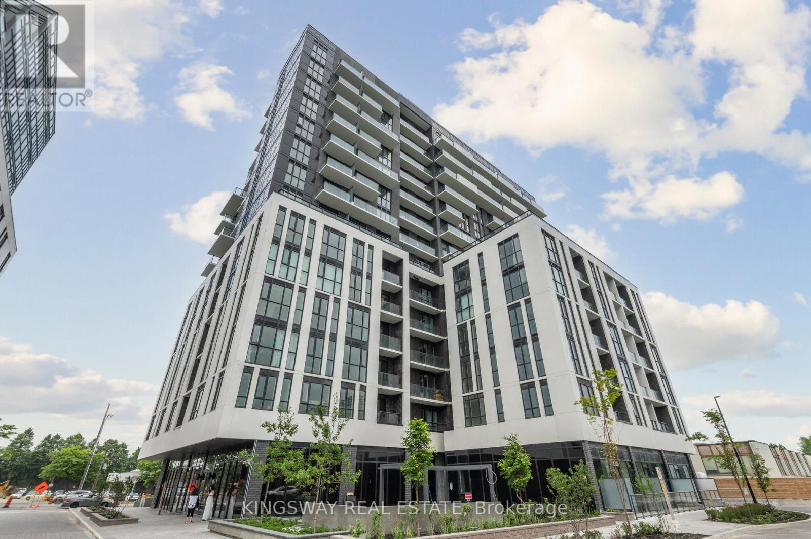 A modern multi-story building with a glass facade and a sign that reads "Kingsway Real Estate Brokerage.".