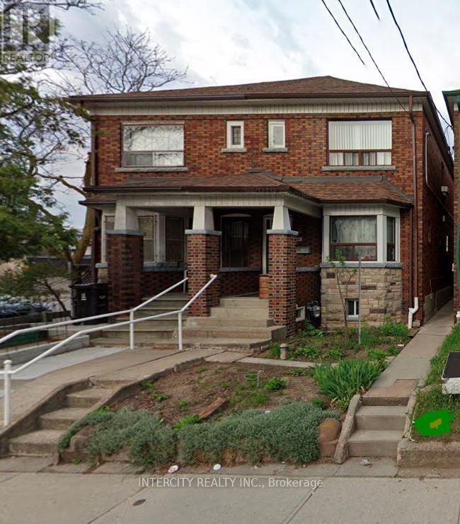 A brick house with a front porch and a small front yard.