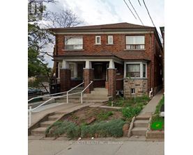 A brick house with a front porch and a small front yard.