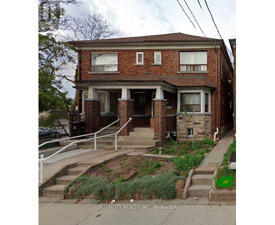 A brick house with a front porch and a small front yard.