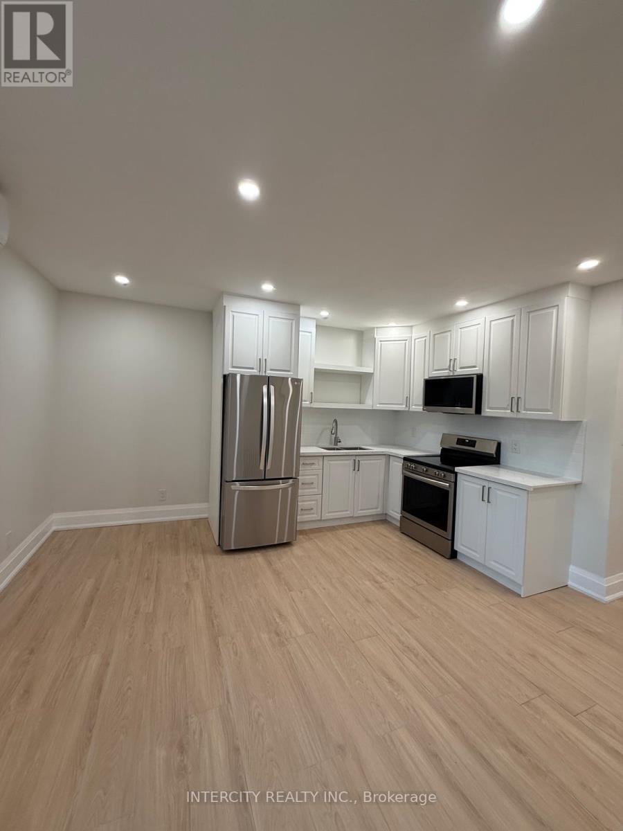A kitchen with white cabinets and a wooden floor.