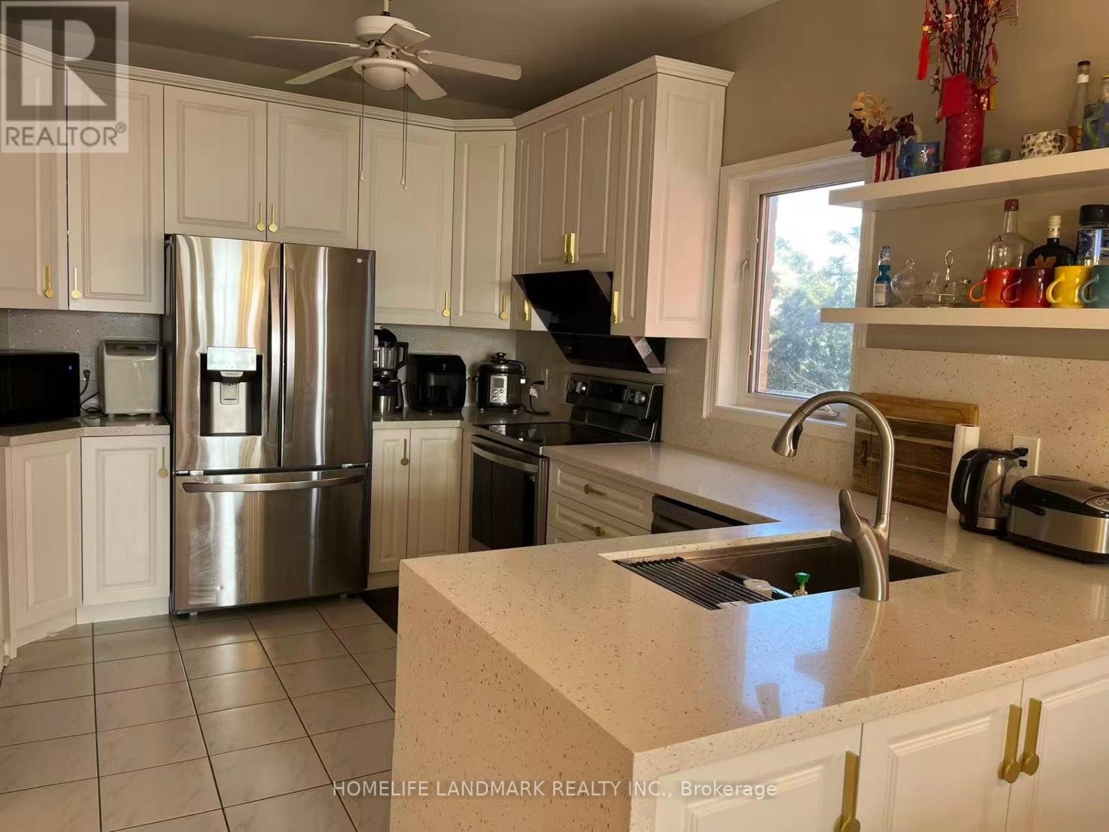 A kitchen with white cabinets and a stainless steel refrigerator.