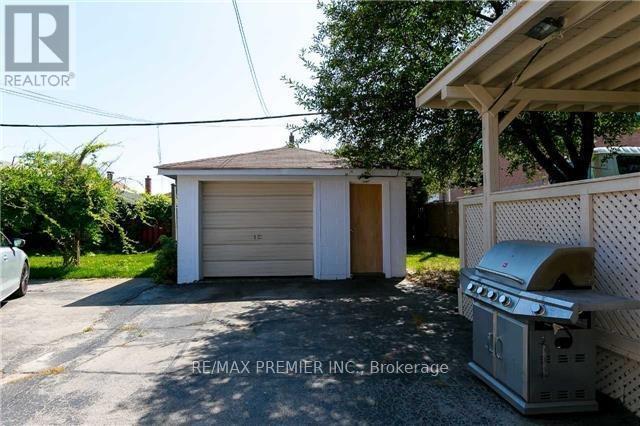 A RE/MAX Premier Inc brokerage sign is displayed in front of a garage.