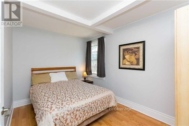 A bedroom with a bed, nightstand, and a picture on the wall.