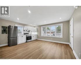 A well-lit kitchen with wooden floors and modern appliances.